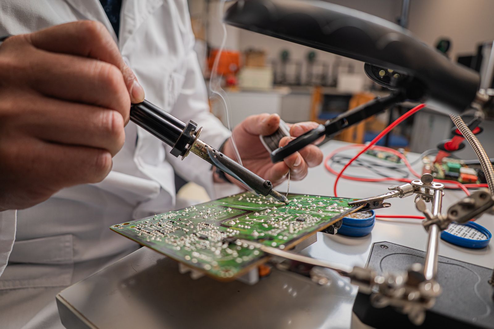 A technician assembling electronic components at a workbench.
